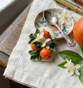 Orange and green leaves and white flowers on pendant